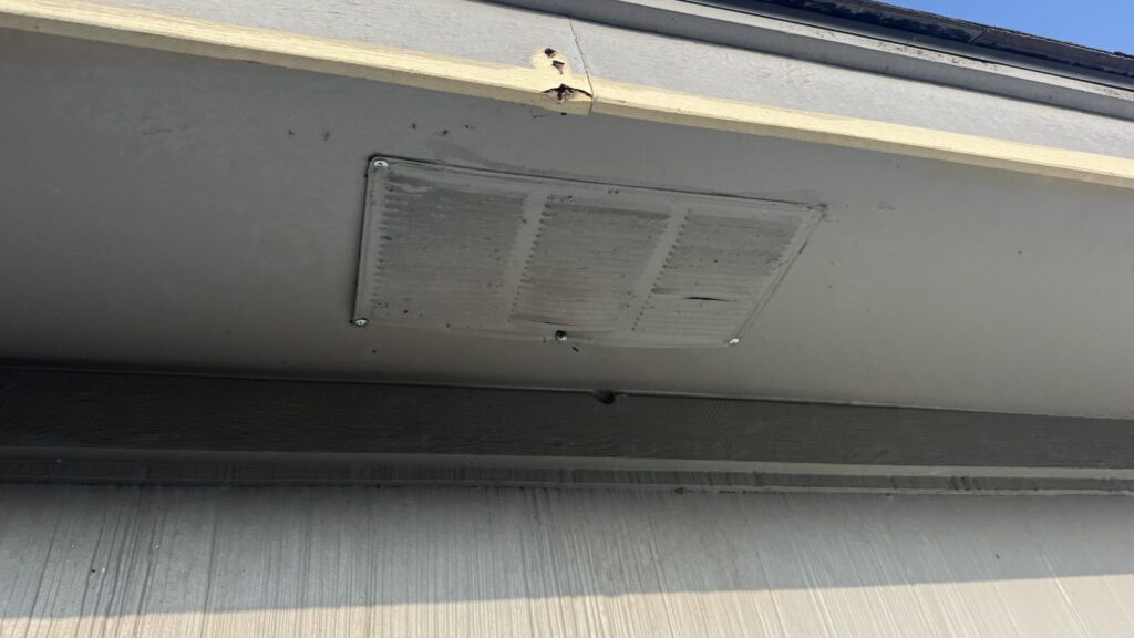 A new metal soffit vent cover fitted over the chewed area, keeping the attic ventilated behind it.