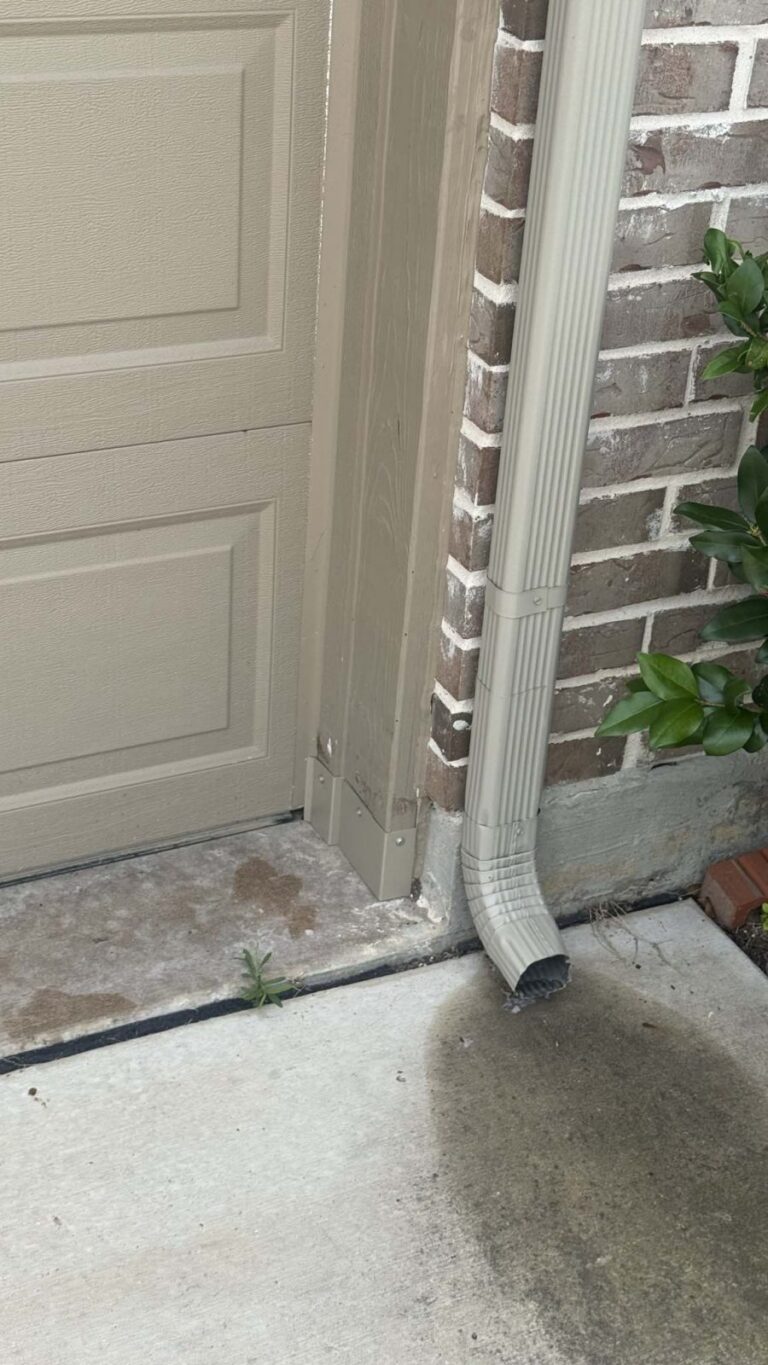 A colour-matched metal guard fitted at the bottom corner of a garage door jamb, closing the gap rodents in the garage had been using.