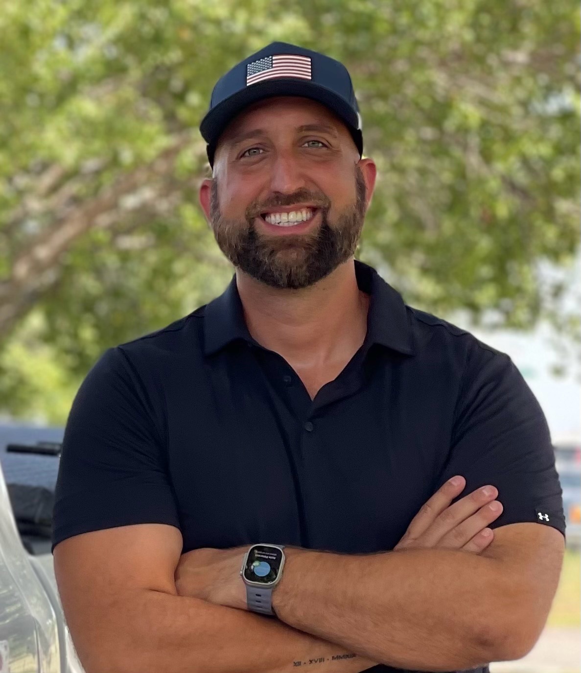 Jordan Hopewell, president of EcoArmor Pest Defense, standing with his arms crossed beside a service truck