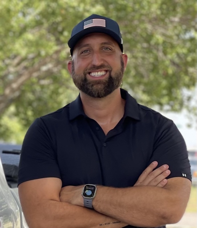 Jordan Hopewell, founder and partner at EcoArmor Pest Defense, standing outdoors with his arms folded.